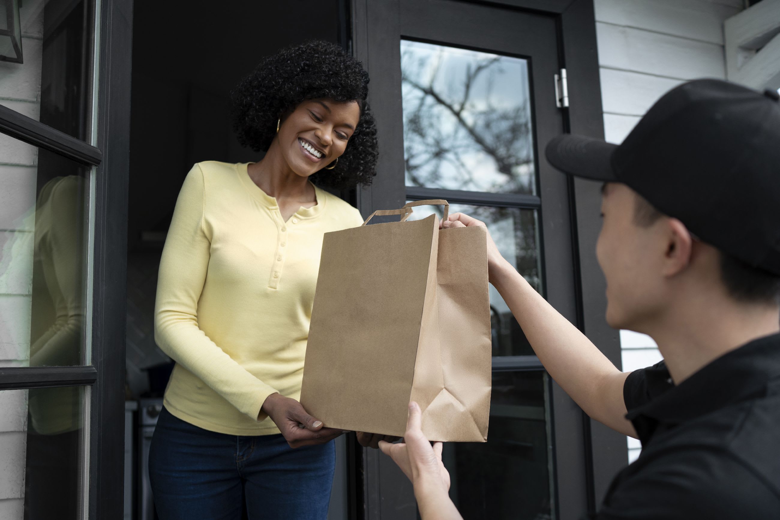 Delivery person handing package to customer